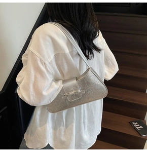 Detail of silver metallic wrinkled leather crescent shoulder bag with modern Y2K style
