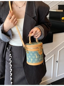 Fashionable denim bucket bag with gold letter patterns and brown leather handle