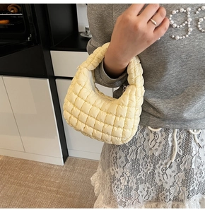 Detailed view of yellow quilted cloud bag featuring soft texture and padded handle