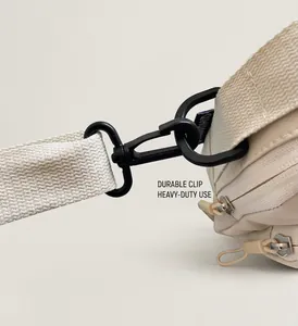 Detail of durable black swivel hook and double zippers on a canvas crossbody bag