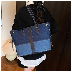 Détail du sac cabas en denim patchwork montrant les couleurs contrastées et le cuir