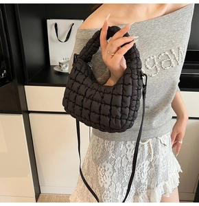 Detail of the black quilted cloud bag showing fluffy nylon texture and crossbody strap
