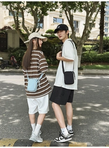 Outdoor street style view of compact crossbody water bottle and phone bags in two colors