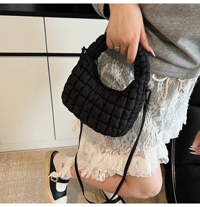 Detail of black quilted cloud bag texture and detachable shoulder strap on outfit