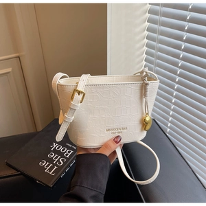 Detail of white crocodile pattern bucket bag with gold buckle and heart charm
