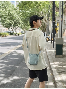 Detail view of light blue nylon crossbody water bottle bag with drawstring closure