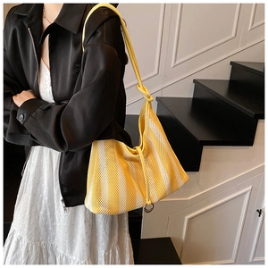 Detail of striped yellow and white hollow mesh tote bag with knot strap and ring metal buckle