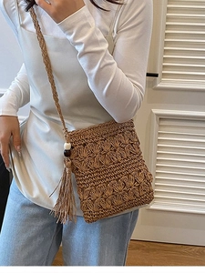 Handmade woven straw crossbody beach bag with flower texture and tassel detail