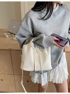 Elegant white bucket handbag with drawstring and silver metal bead charm accessory