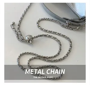Detailed close-up of the silver hardware chain strap and metal adjustment ball on the bag