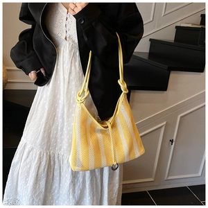 Detailed view of yellow striped mesh tote bag featuring trendy knotted leather shoulder strap