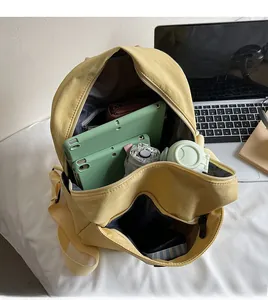 Interior view of yellow canvas backpack showing spacious capacity for tablets and water bottles