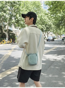 Detail view of mint green nylon crossbody water bottle and phone bag with drawstring closure