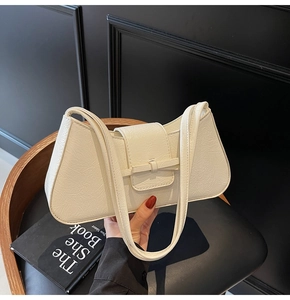 Detail of cream white pleated faux leather shoulder bag with glossy texture and twin straps