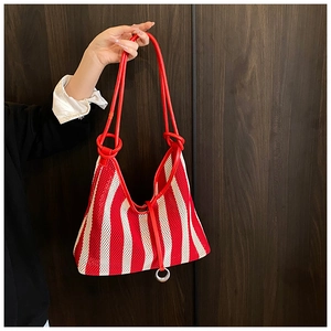 Detail of red and white striped mesh tote bag with smooth leather handles and metal ring