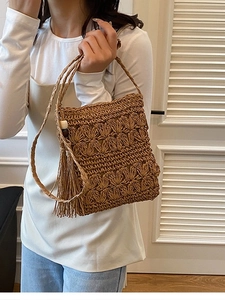 Handmade brown straw crossbody beach bag with floral knit texture and large tassel charm