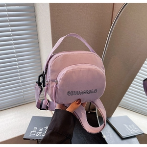 Detail of light purple nylon crossbody bag showing the dual zippers and durable fabric texture