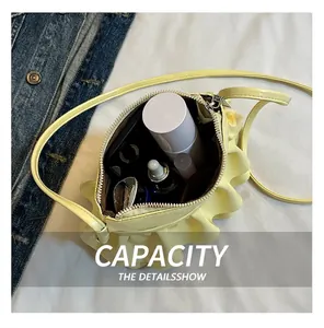 Internal view of mini yellow pleated crossbody bag showing storage for makeup items