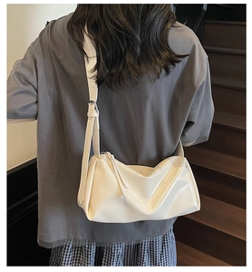 Detailansicht der cremeweißen Lackleder-Schultertasche mit weichem Faltendesign-Stil