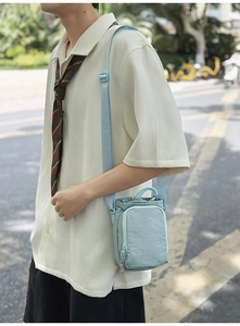 Detail of mint green nylon crossbody phone bag showing wrinkled fabric and drawstring closure