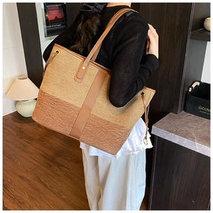 Large canvas tote bag with brown leather trim and shoulder straps shown in lifestyle setting