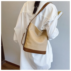 Close-up of woven shoulder bag with brown leather trim and natural beige texture