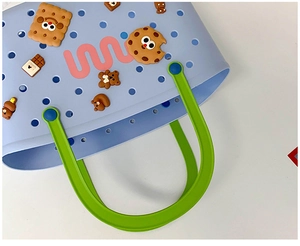 Detail of light blue bath basket with green handles and cute 3D cartoon charms
