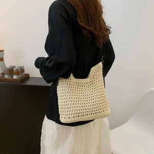 Detail of cream crochet shoulder bag showing fine mesh texture and brown leather strap