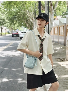 Light blue nylon crossbody bag with dual zipper compartments and adjustable shoulder strap