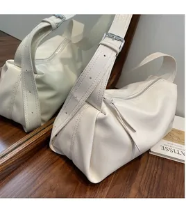 Details des verstellbaren Schultergurts und der Silberschnalle an einer weißen Tasche