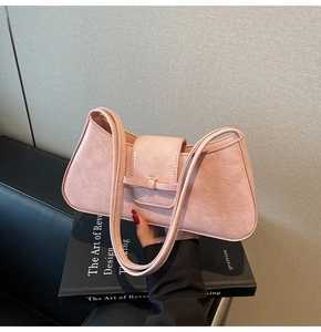 Close-up of pink underarm bag featuring vintage wrinkled texture and leather buckle detail