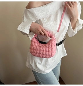 Pink quilted cloud bag shown on model with shoulder strap and nylon fabric detail