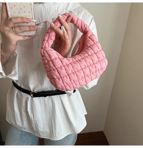 Detail of pink quilted bubble bag with soft nylon texture and crescent shape design