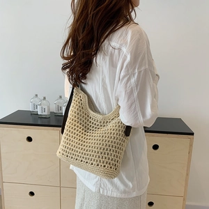 Detailed view of beige handmade crochet tote bag with textured mesh and brown leather strap