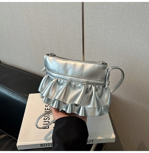 Detailed close-up of a silver pleated mini bag featuring metallic ruffles and fine strap