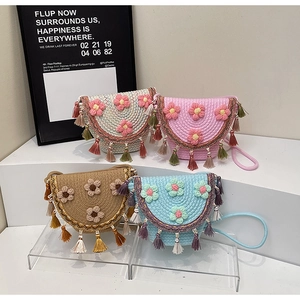 Close-up of woven bucket bags featuring 3D crochet flowers and colorful tassel charms