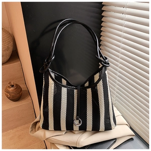 Detail of hollow mesh bag with black and white vertical stripes and metal ring buckle