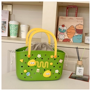 Detail of green EVA tote with yellow handles and cartoon charms showing the drawstring liner