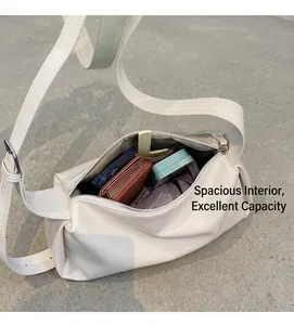 Draufsicht auf das geräumige Innenleben der cremeweißen Ledertasche mit Utensilien