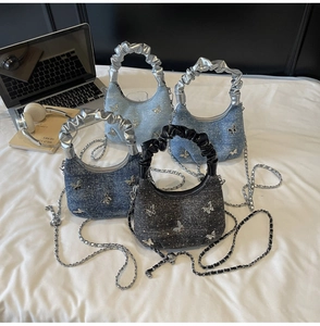Dettaglio di quattro borse hobo in denim con ciondoli a farfalla e manici increspati