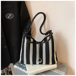 Detail of hollow mesh bucket bag with black leather straps and silver ring fastener