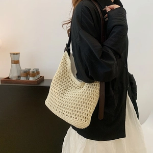 Detailed close-up of cream crochet shoulder bag with brown leather straps and woven mesh