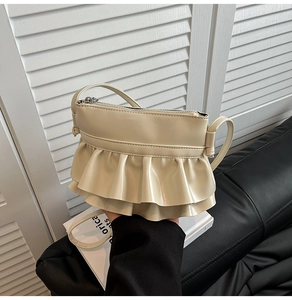 Detail of cream ballet-style crossbody bag featuring double-layered ruffled PU leather