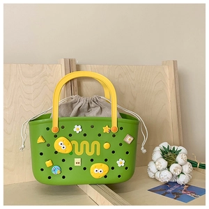 Detail view of a green EVA bath basket with yellow handle and a cotton drawstring liner