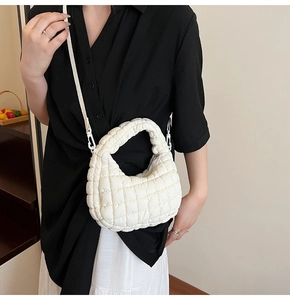 Detail view of white quilted cloud crescent bag with plush nylon texture and zipper closure