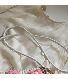 Detail of handcrafted woven mini bucket bag with cotton rope strap and crochet flowers