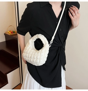White quilted cloud bag with rhombus texture shown on shoulder for sizing