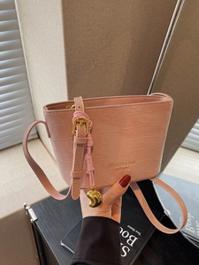 Pink faux leather bucket bag with crocodile texture and gold crescent charm decoration