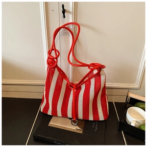 Detail of red and white striped knit mesh tote bag with sturdy tubular handles