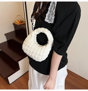 Detail of white quilted cloud bag with plush texture and adjustable shoulder strap